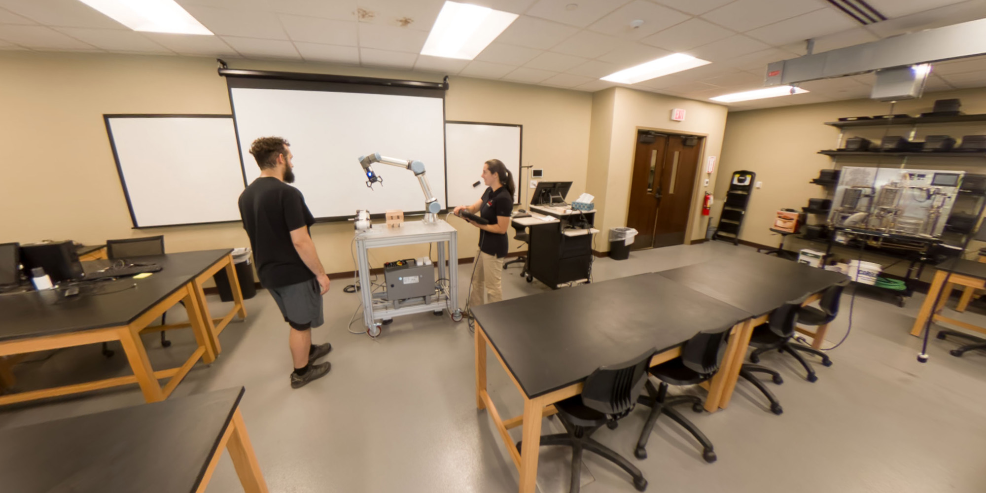 Students interacting with an industrial robot in an engineering lab
