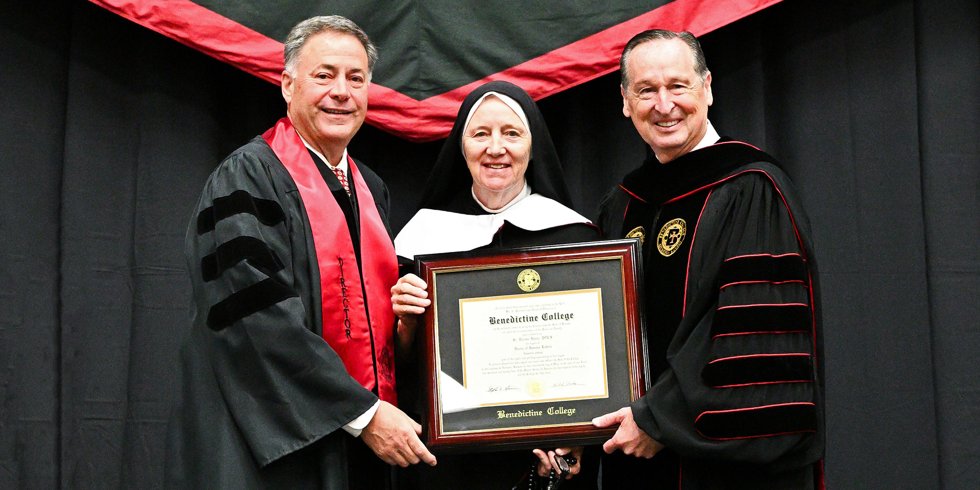 Sister Deirdre Byrne, POSC, holds her Doctorate of Humane Letters award, flanked by President Stephen Minnis and Chairman of the Board Mike Kuckelman