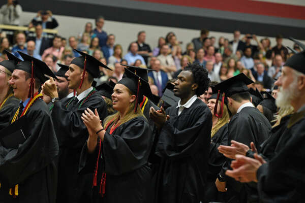 graduation class with caps on in the gym