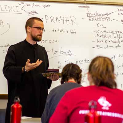 A monk teaches students in a class