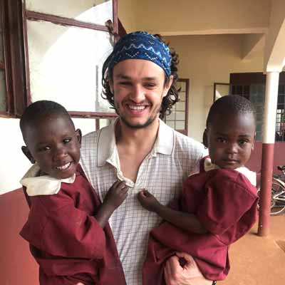 A student holds two children while on a mission trip