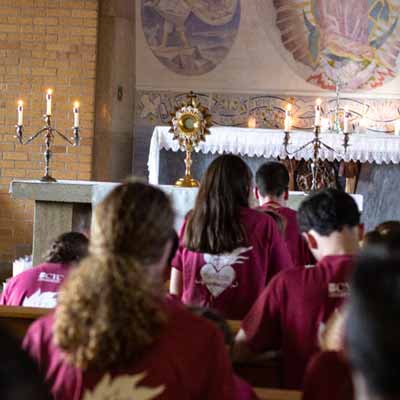 Students kneel during Eucharistic Adoration